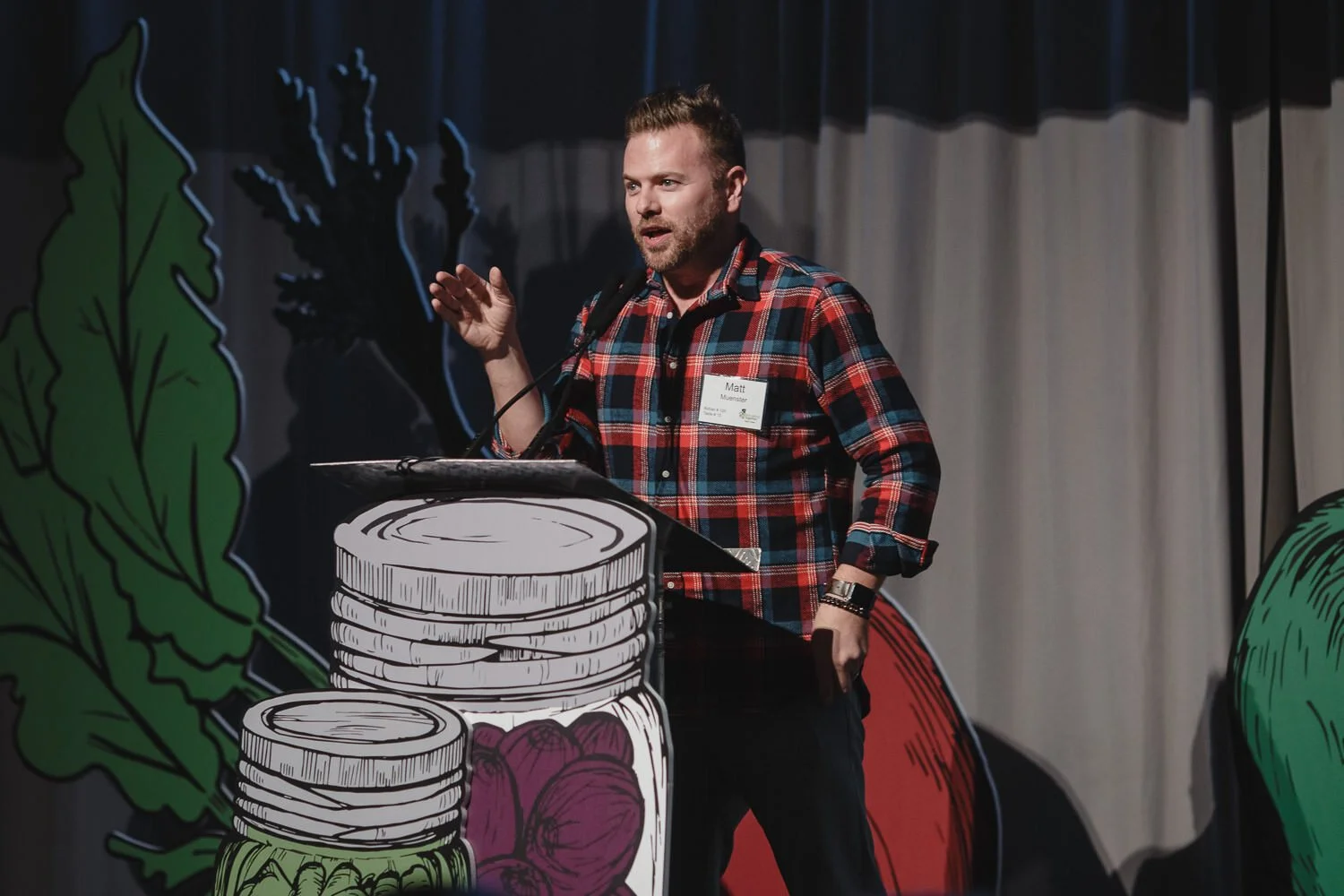 speaker in flannel shirt at Americana farm themed event