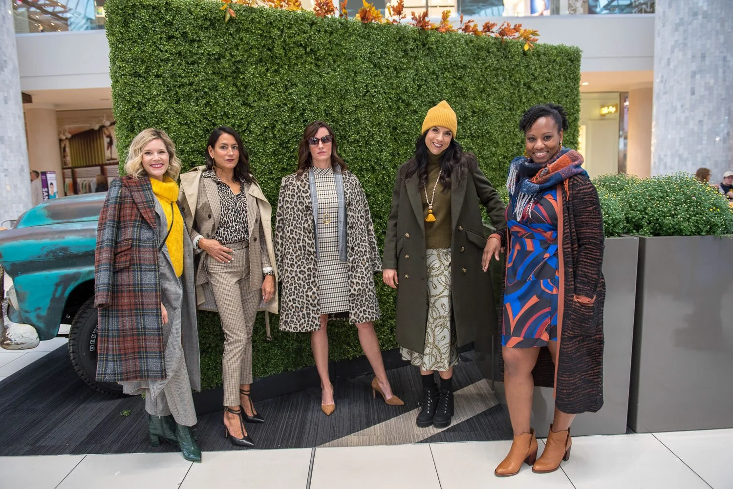 models pose in front of topiary wall at British inspired fashion event