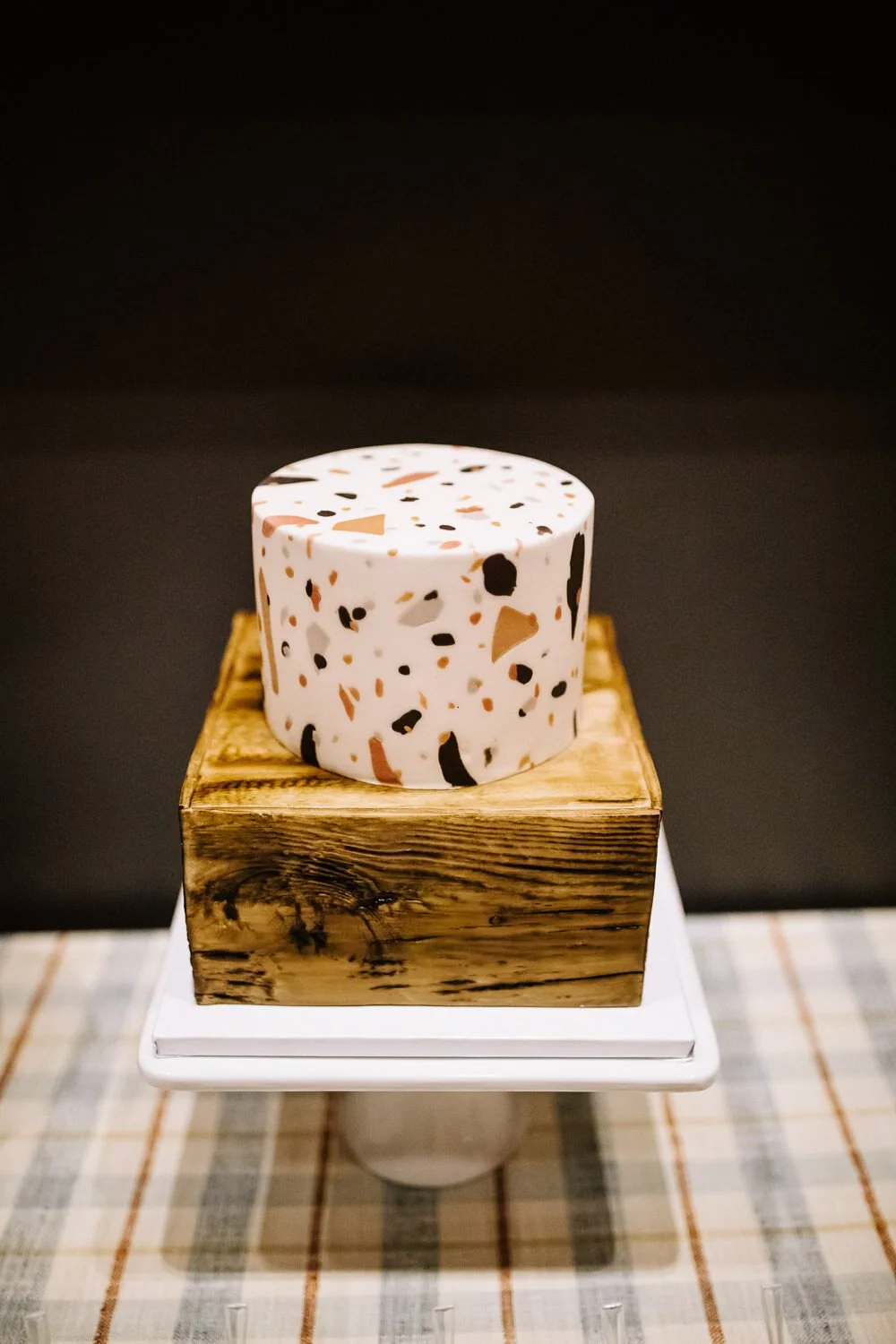 two tiered wedding cake with geometric design and faux wood design