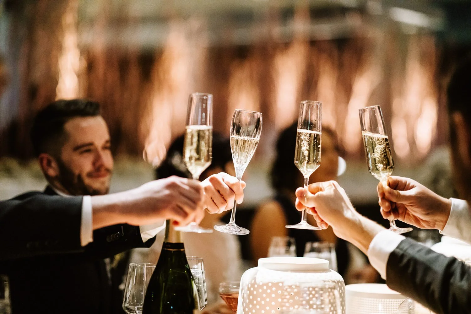 wedding guests clink champagne glasses during toast