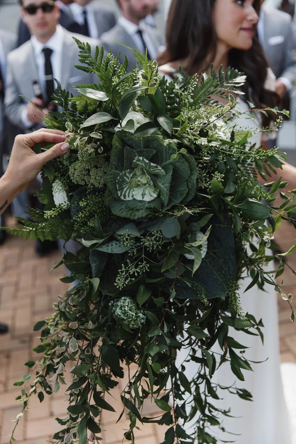 bride holding large all green bouquet