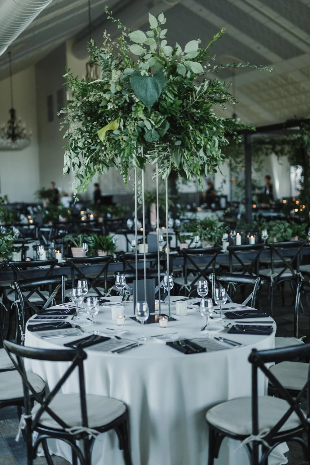 wedding reception tablescapes with black and white design and tall all green floral centerpiece