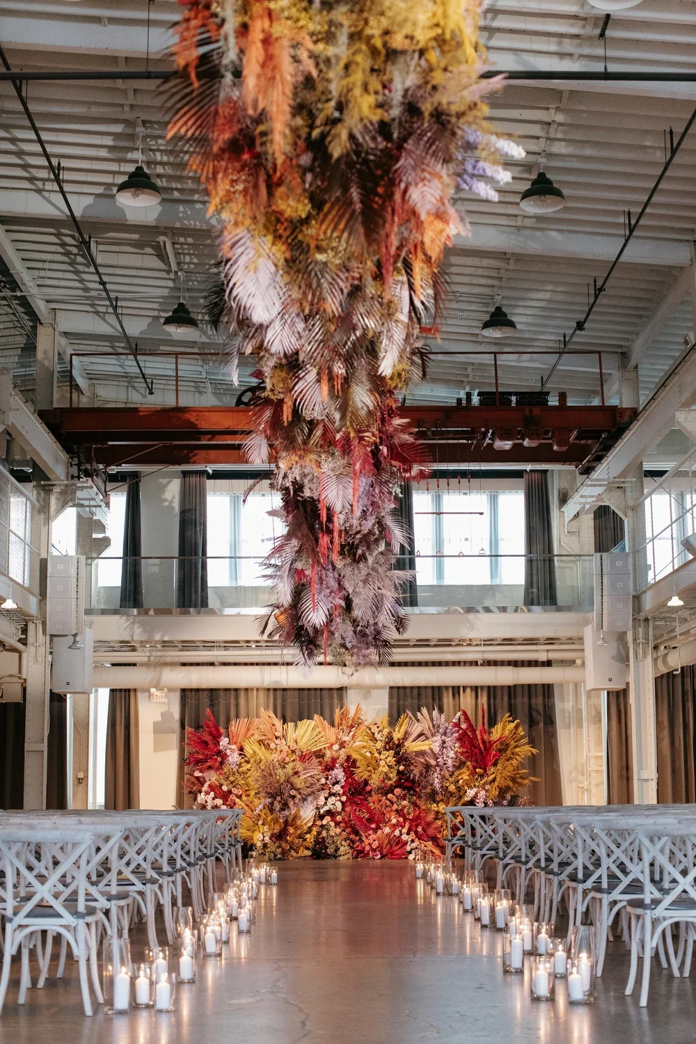 fall-ceremony-at-machine-shop-with-dramatic-ceiling-installation-down-the-aisle.webp
