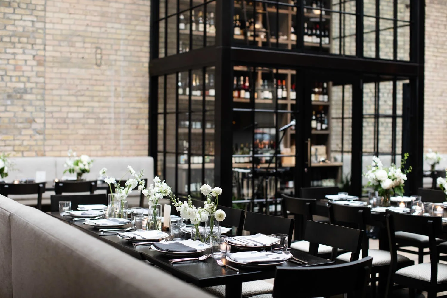 Black long tables and chairs with white tableware and white daisies placed perfectly. Minneapolis rehearsal dinner, Spoon and Stable restaurant, Designed by Rocket Science Events.