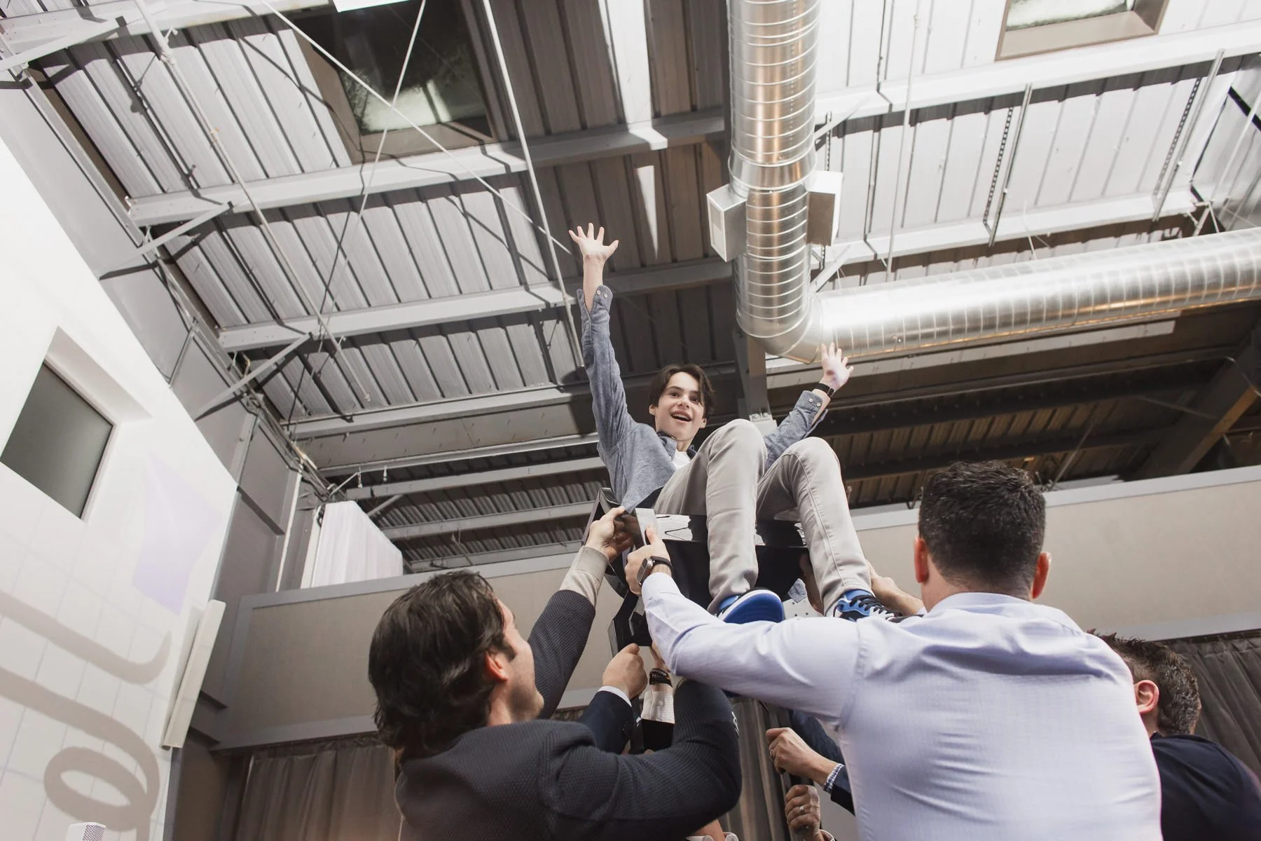 A boy being lifted in a chair during the hora at a Minneapolis Bar Mitzvah planned by Rocket Science Events