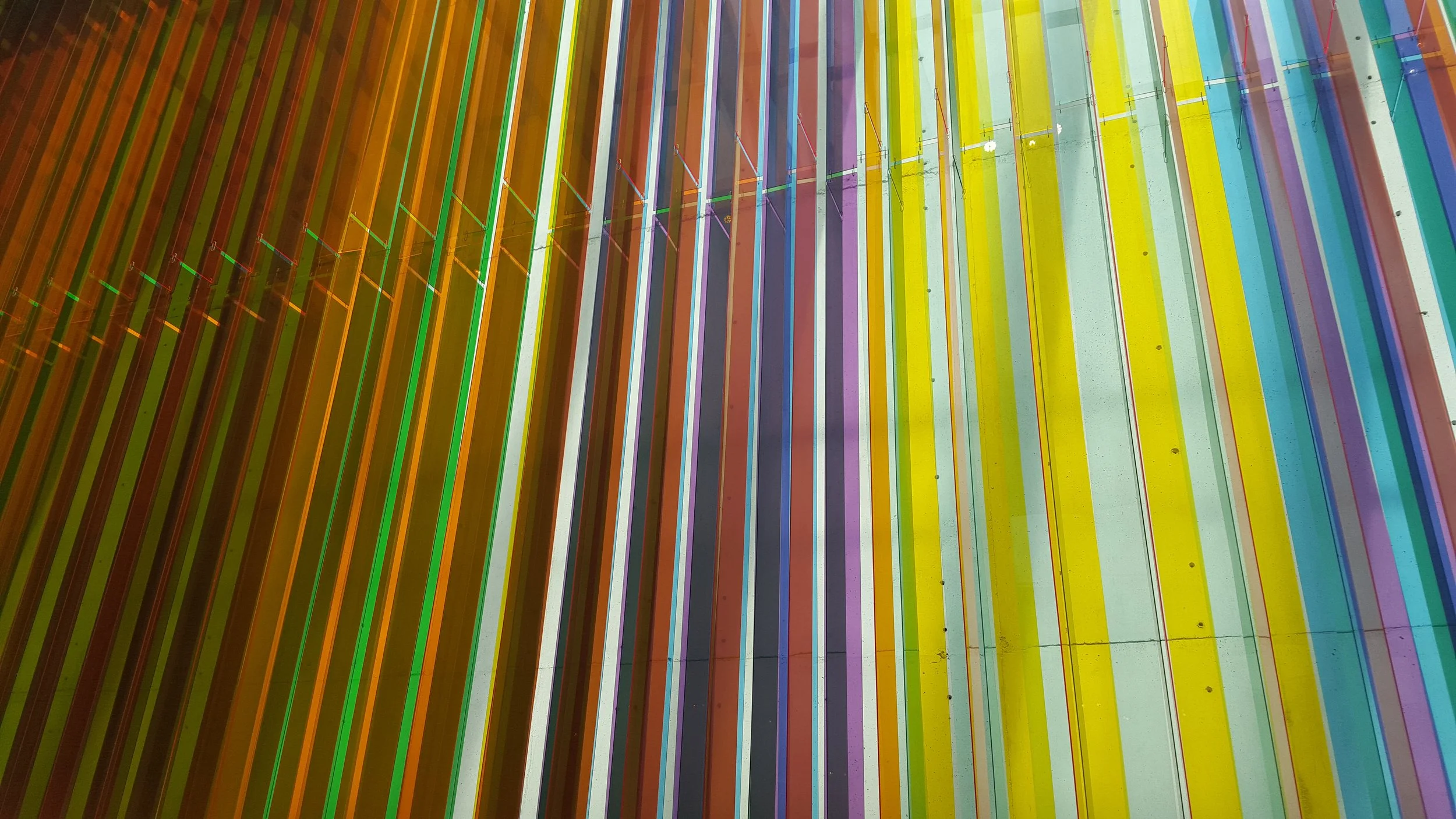 Colorful rainbow-colored slats arranged vertically in parallel lines.
