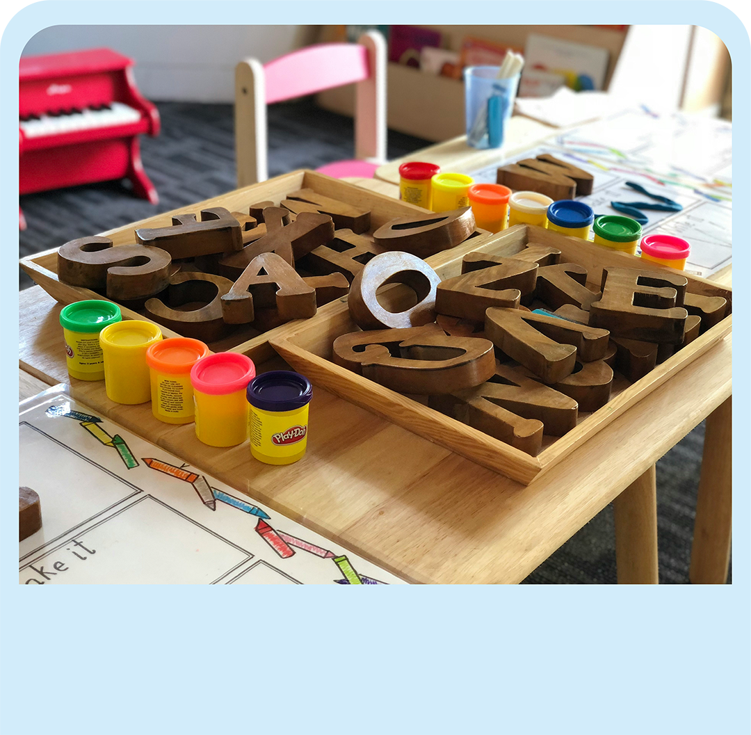 Kindergarten classroom with wooden letter blocks and play-doh