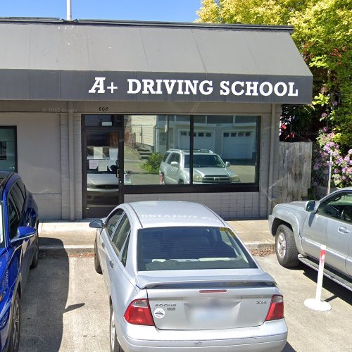 Front view of a driving school building with a black awning displaying