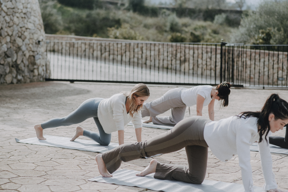 Drei Frauen beim Yoga im Freien auf einer Terrasse