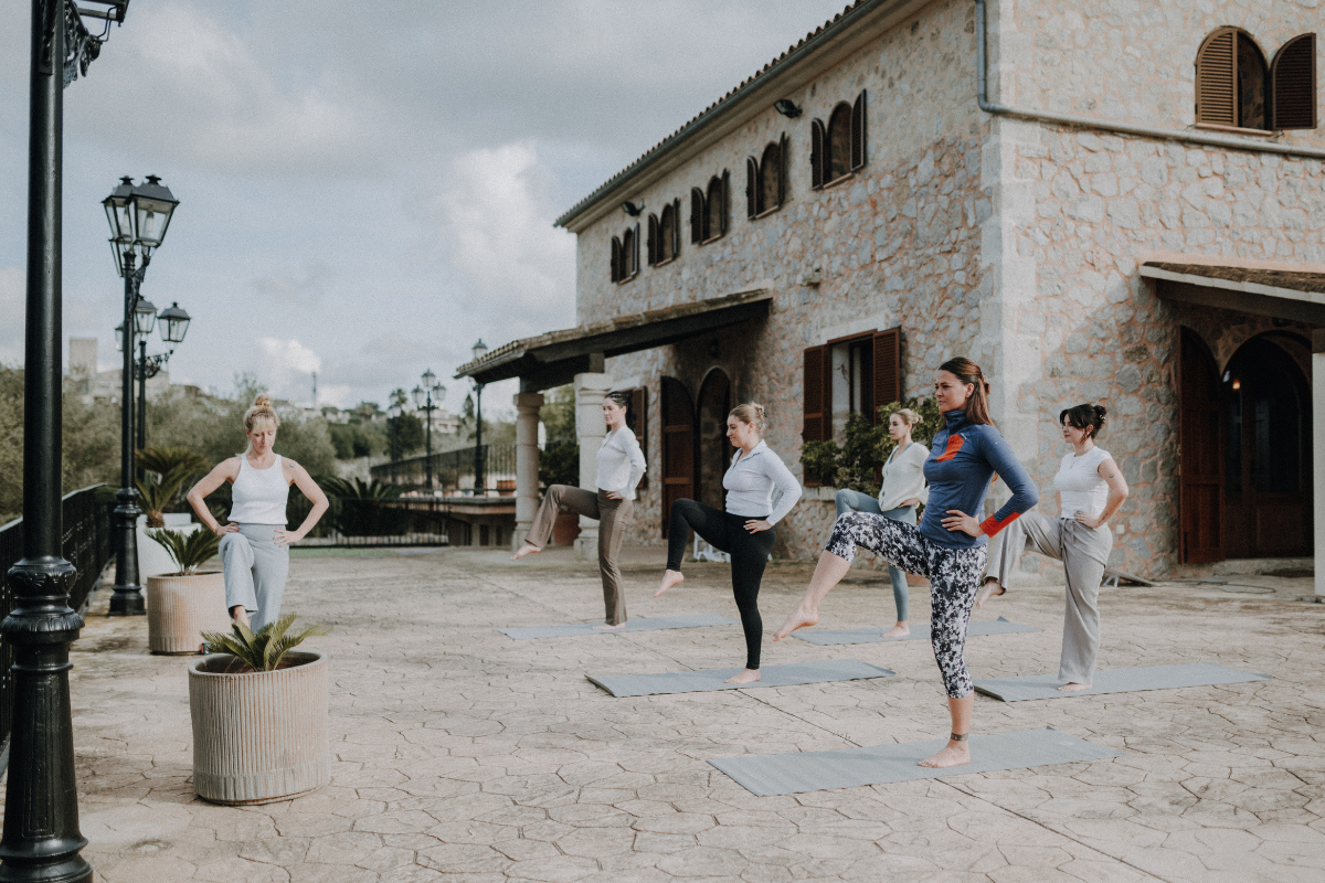 Frauen beim Yoga im Freien auf einer Terrasse in einer Kirche