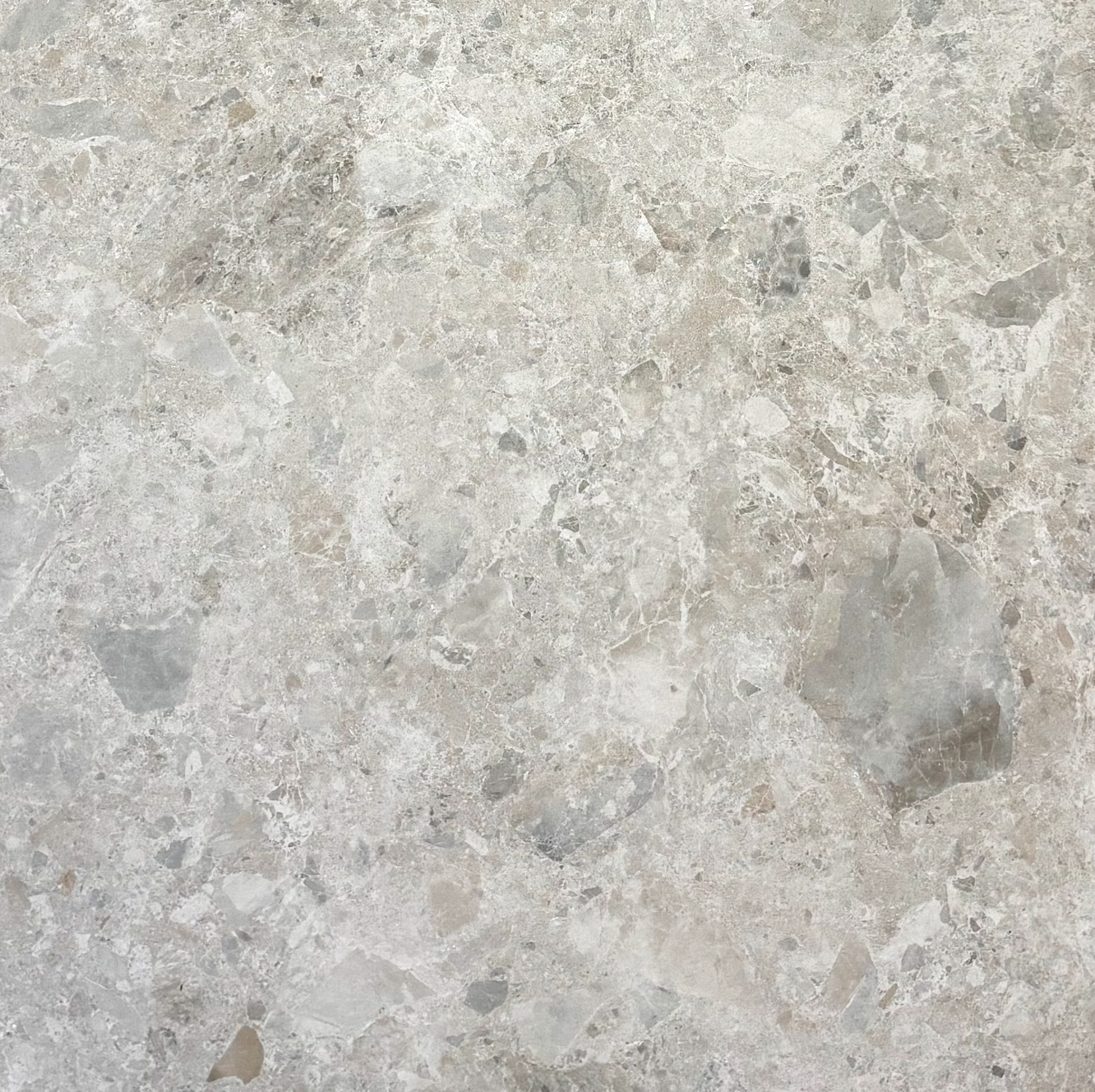 Close-up of a beige and gray stone or marble surface with a natural pattern.