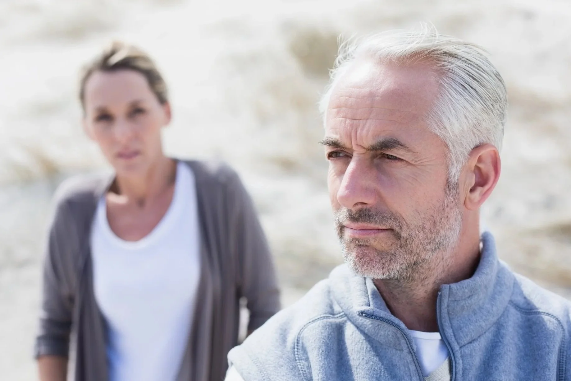 Couple standing quietly together, reflecting on recurring relationship challenges