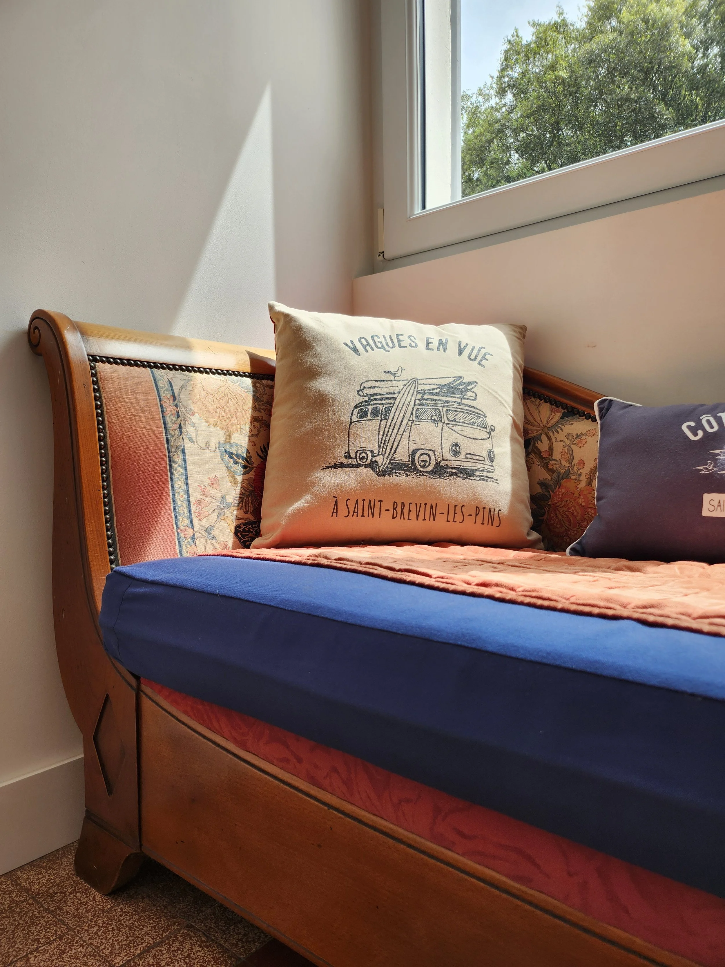 Coussin avec une illustration d'un van Volkswagen avec une planche de surf dessus et le texte 'VAGUES EN VUE' et 'À SAINT-BREVIN-LES-PINS'.