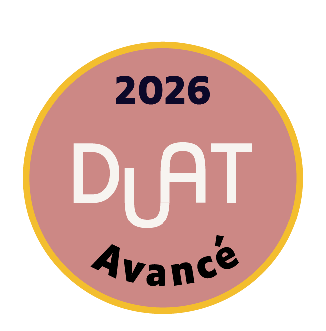 A circular badge with a pink background and yellow border, displaying the text "2026 DÛT Avancé" in black and white.