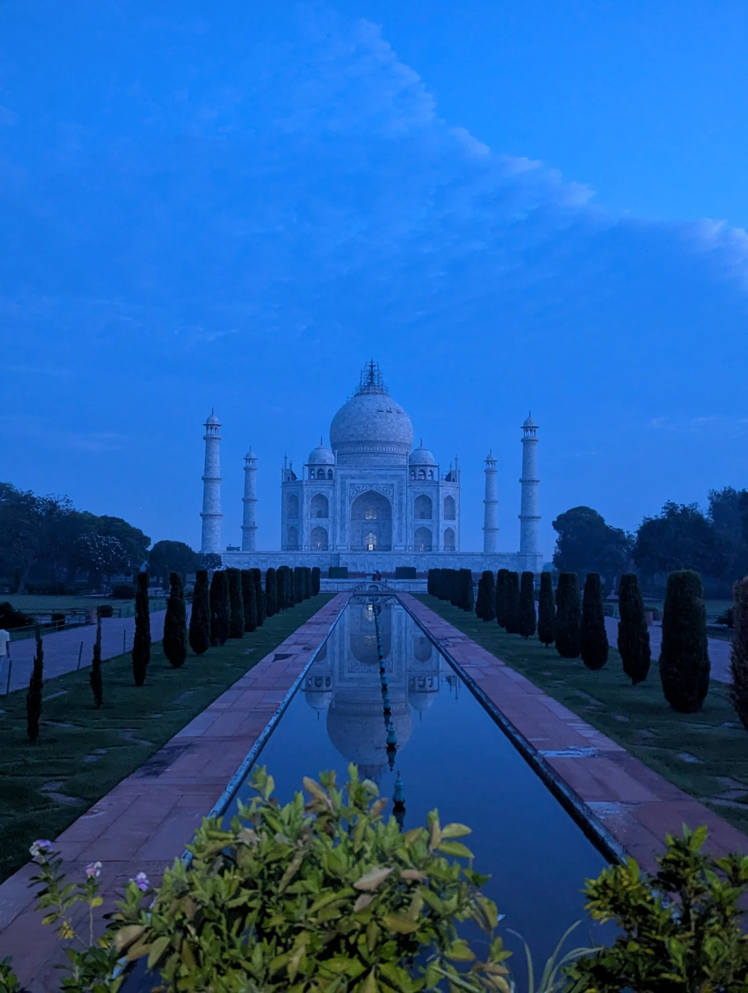 Le Taj Mahal au coucher du soleil avec une réflexion dans le bassin devant.