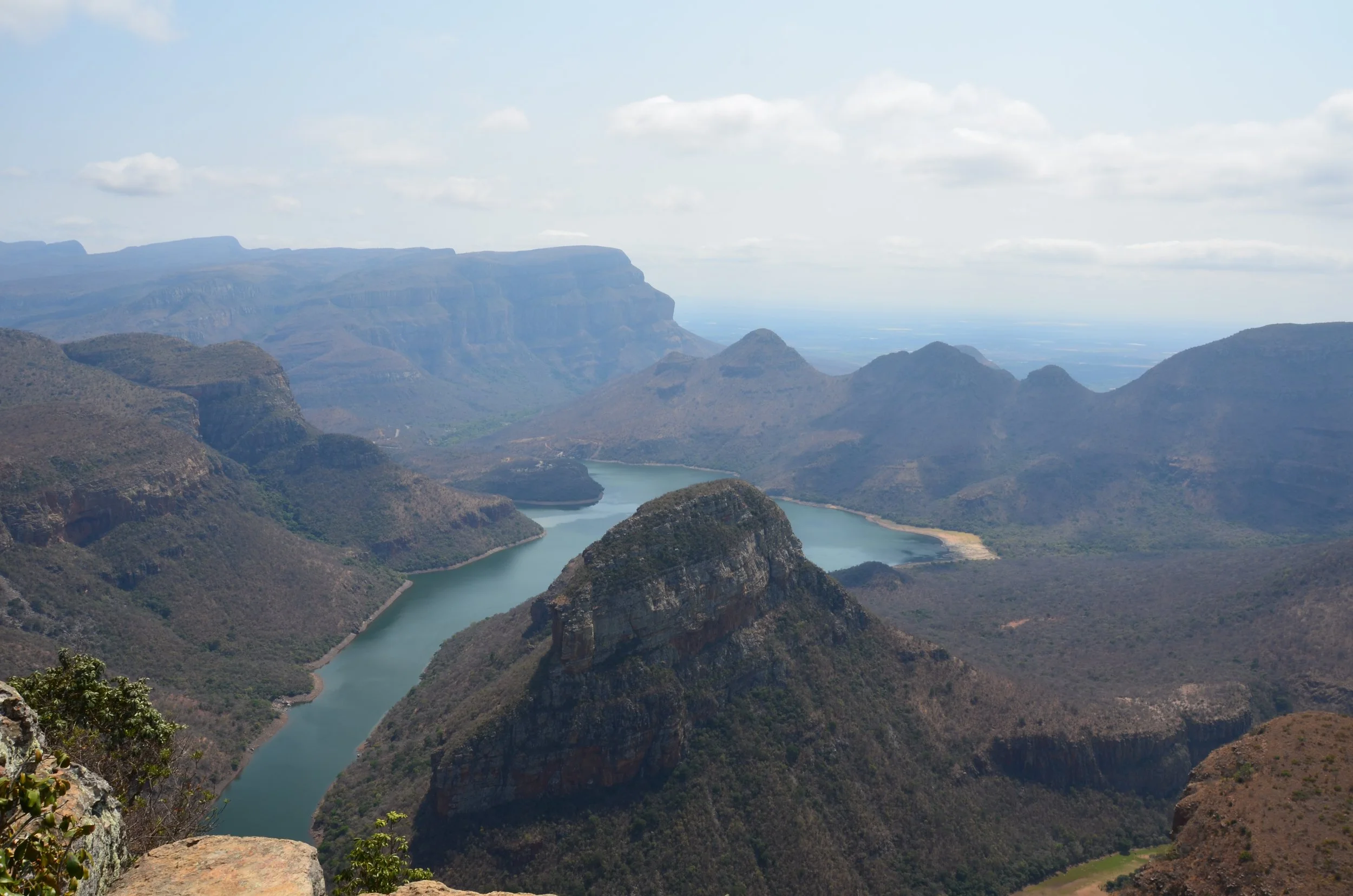 Vallée avec une rivière serpentant à travers des montagnes rocheuses, paysage de canyon avec des sommets rocheux et des collines verdoyantes