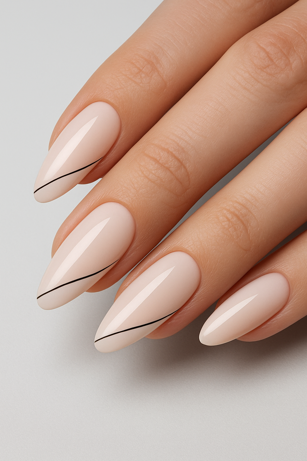 Artificial nails in almond shape with soft nude colour and fine line detail
