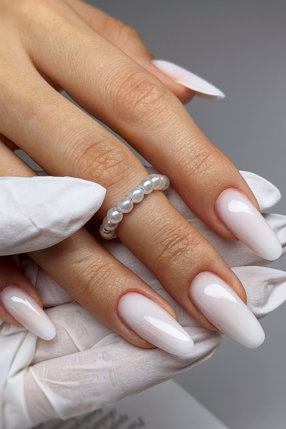 Artificial nails in almond shape with soft nude colour and fine line detail