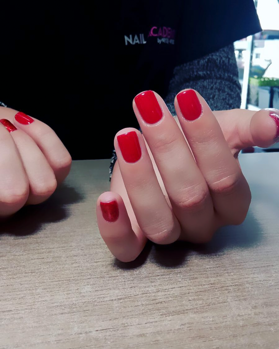 Professional red manicure with clean nail shape and finish