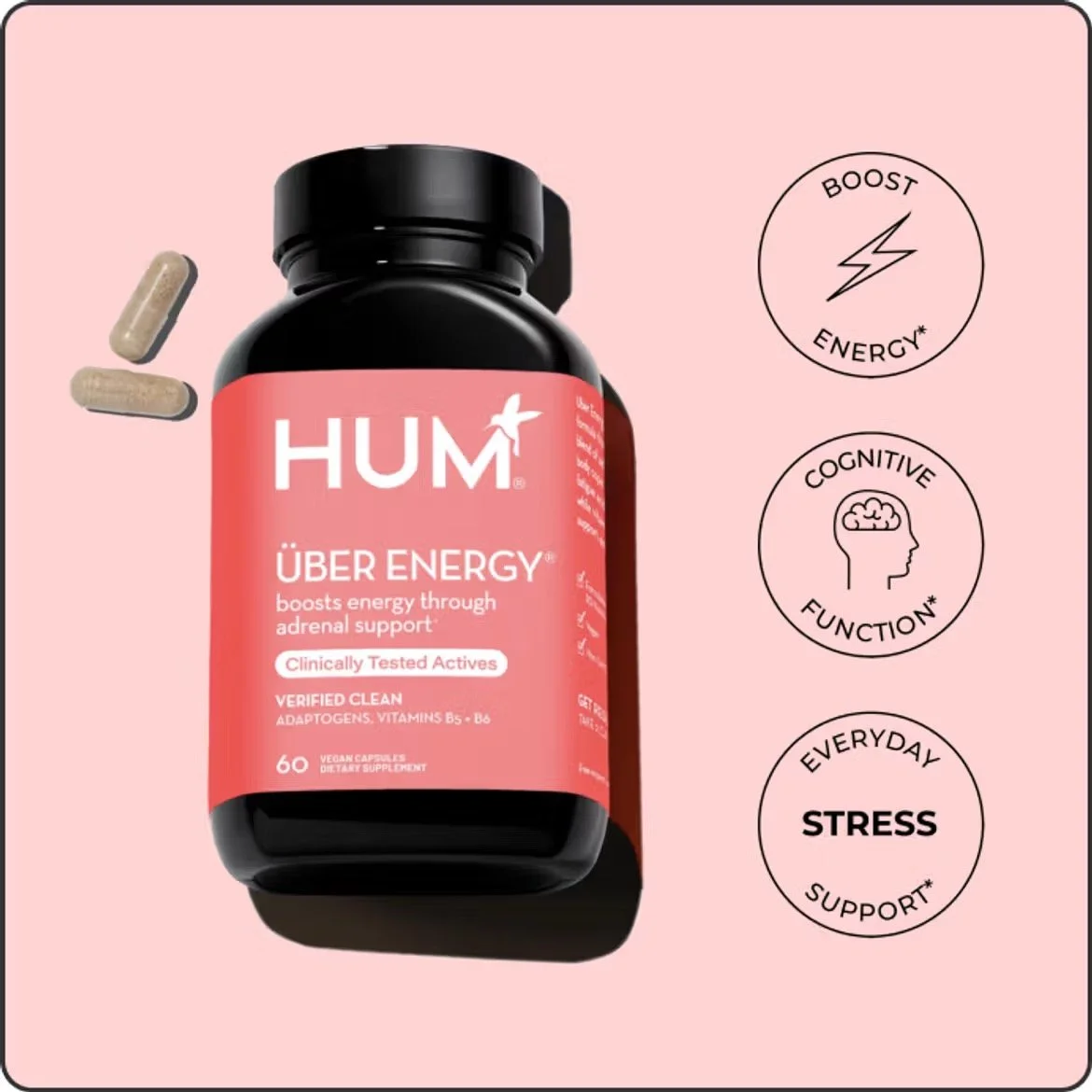 Bottle of HUM Über Energy dietary supplement with two capsules next to it, pink background, icons indicating boosts in energy, cognitive function, and stress support.