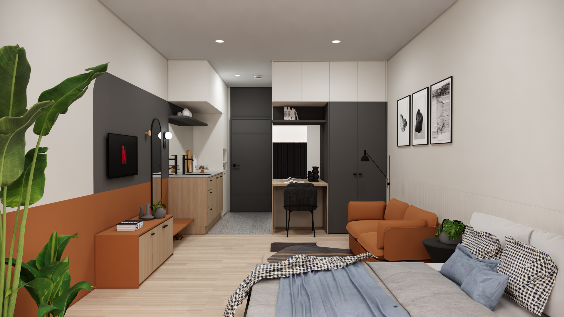 Modern living space with kitchen, sitting area, and bedroom visible. Features a large bed with checkered pillows, an orange armchair, a TV mounted on a dark wall, a wooden console, and leafy houseplants.