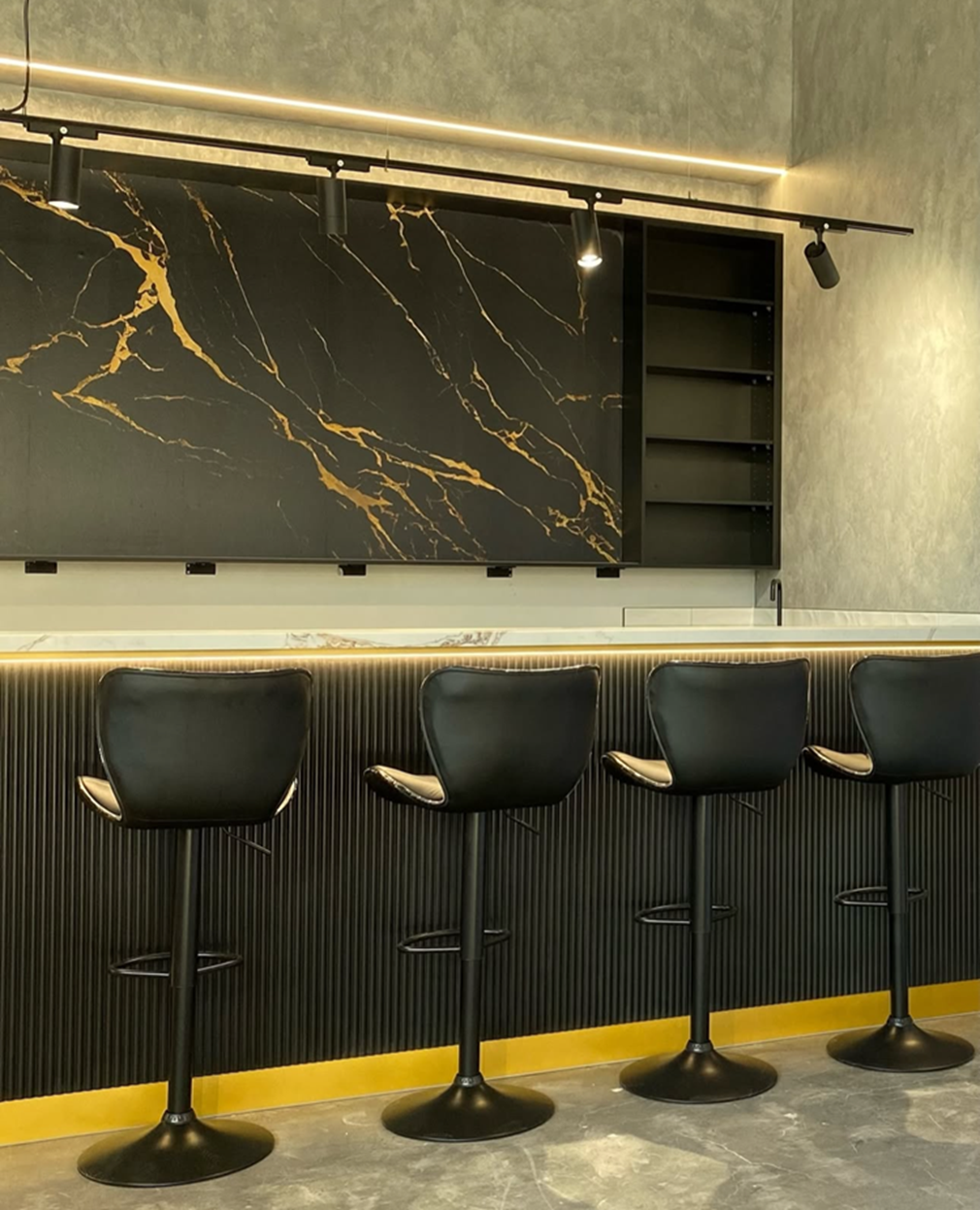 Interior of a luxury boutique with green-lit shelves displaying handbags, shoes, scarves, and accessories. Mannequins and display cases showcase jewelry and other items. The floor has a black and white checkered pattern.