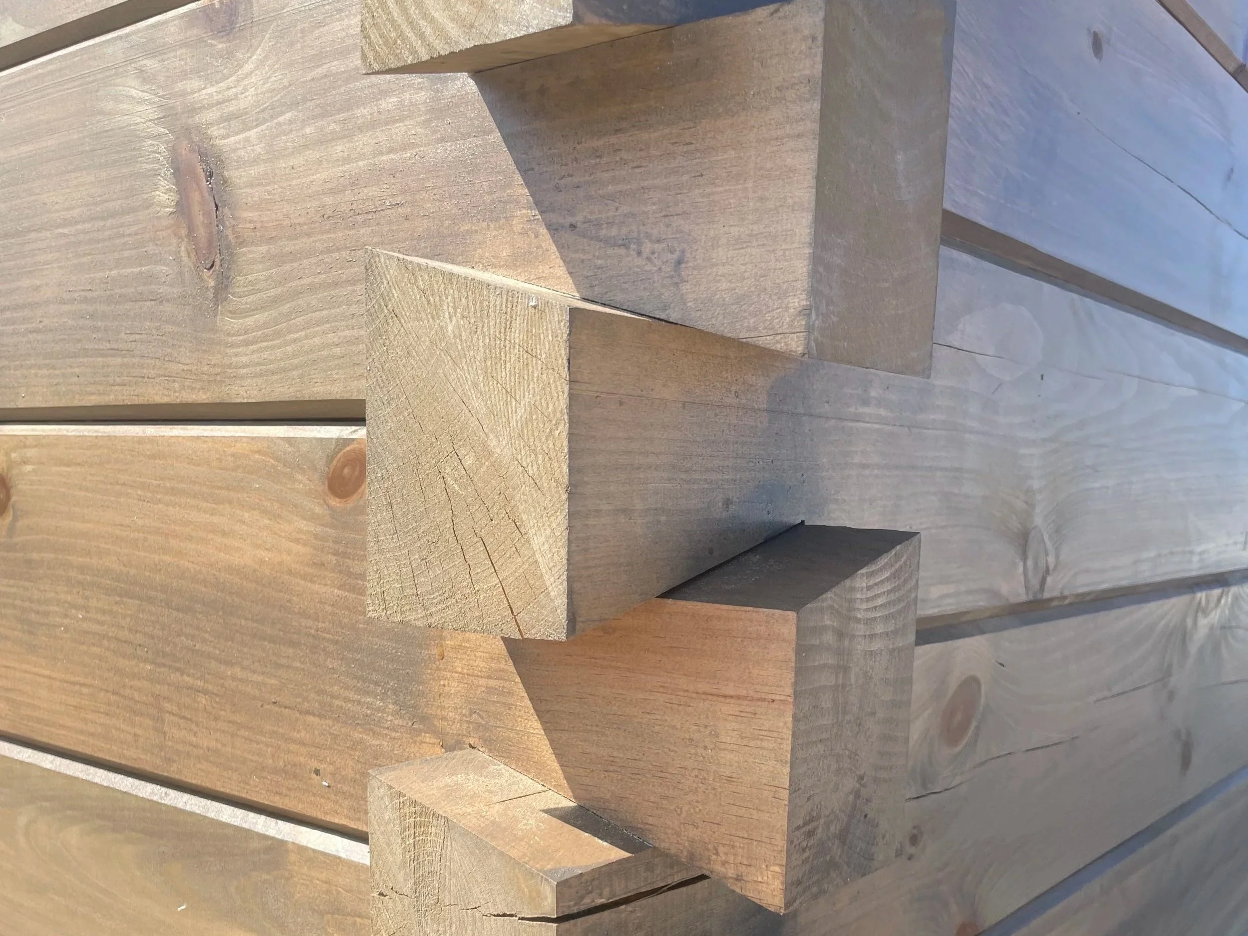 Close-up of stacked wooden blocks with visible wood grain and knots.