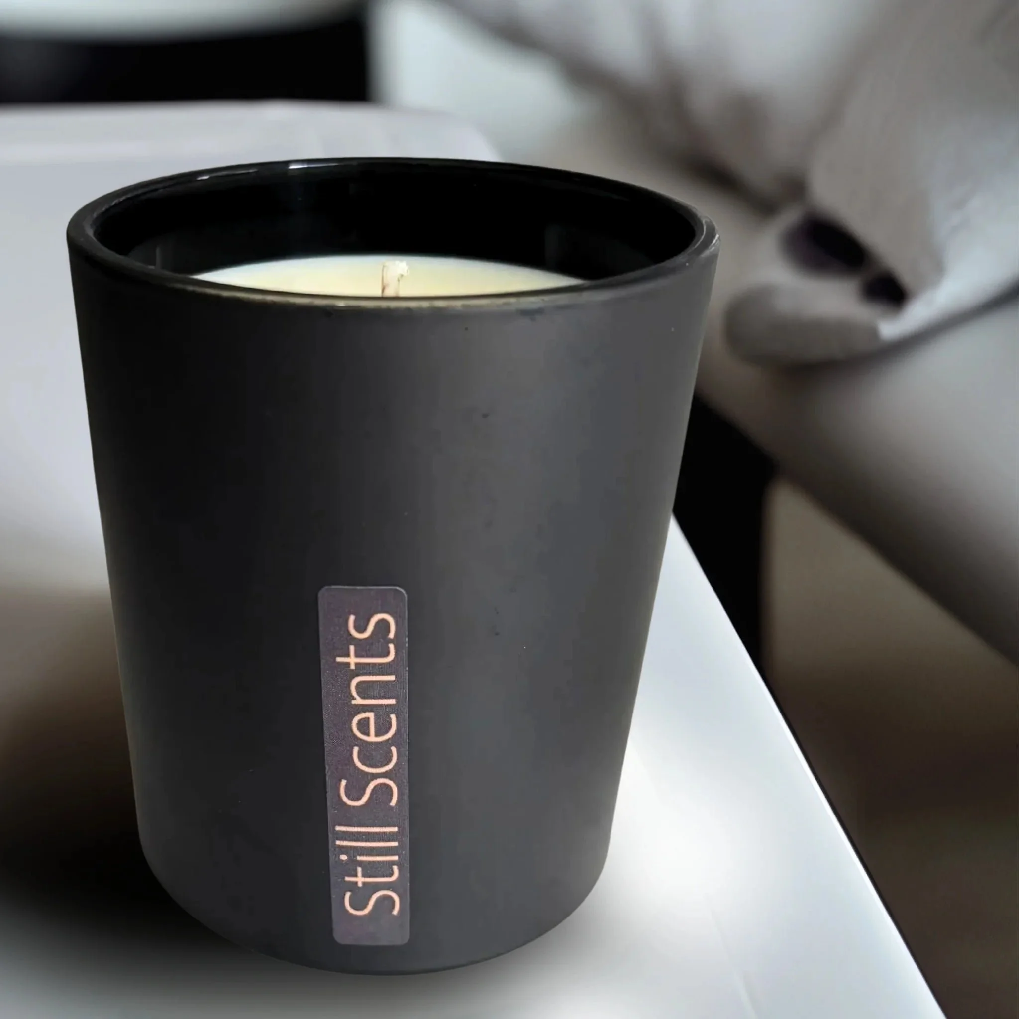Matte black candle with 'Still Scents' on the side.