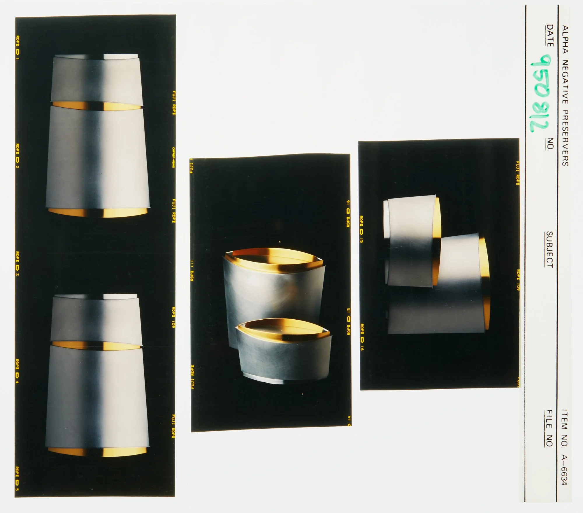 Photograph of modern metallic containers with gold accents, includes two tall, stacked containers, a pair of rounded containers one on top of the other, and a pair of smaller, angled containers.