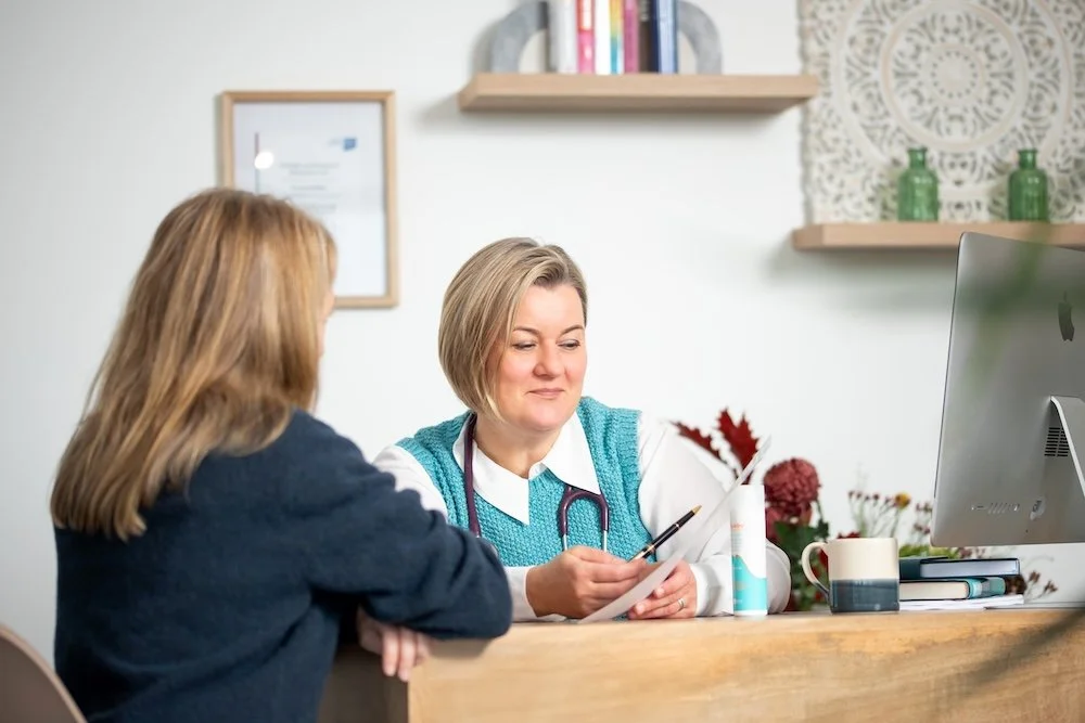 Dr Lucy Mather having a consultation with a patient in a medical clinic.