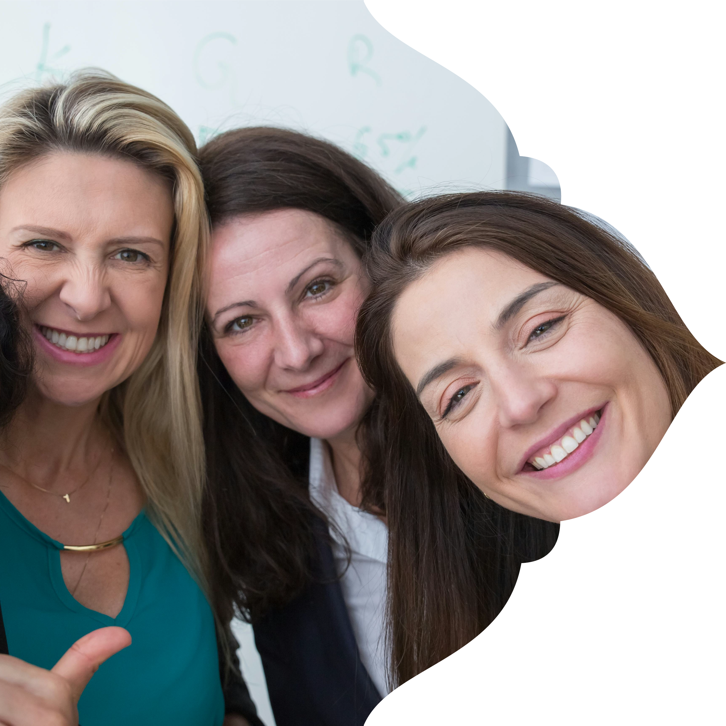 Three smiling women close together, posing for a photo indoors with a light background.