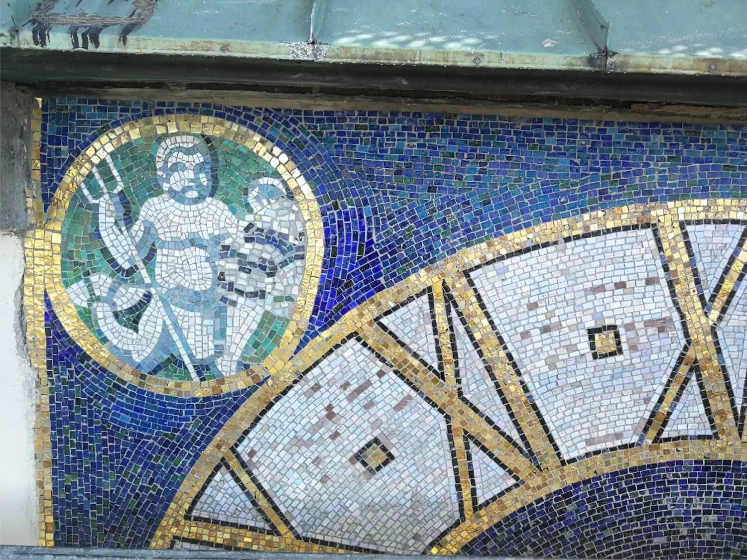 Vier Mosaik-Ziffernblätter am Turm eines Schulgebäudes