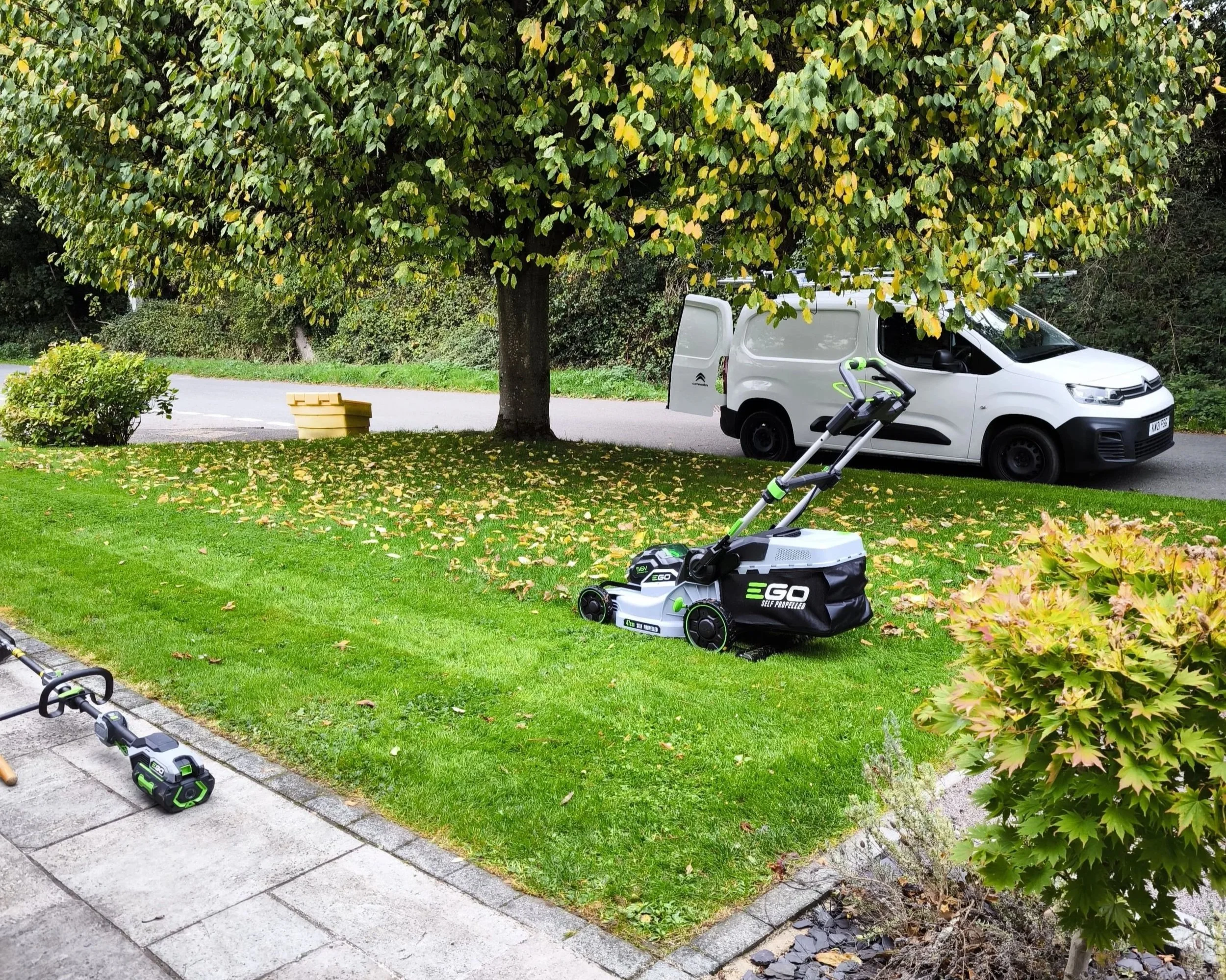 Lawn mower cutting and maintaining a garden lawn.