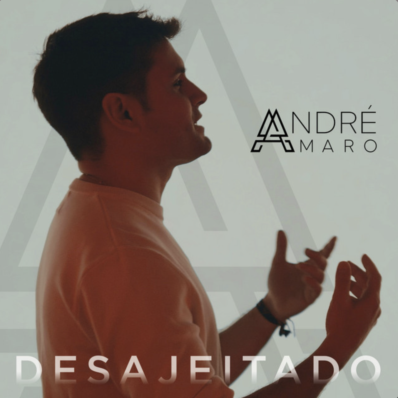 Profile of a young man with short brown hair looking to the right, wearing a peach-colored shirt, gesturing with hands, standing before a light backdrop with the text 'ANDRÉ MARO' and the word 'DESAJETADO' at the bottom.