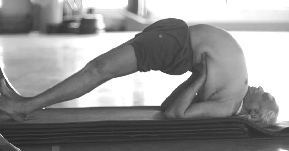 BKS Iyengar in his later years demonstrating setu bandha sarvangasana on top of the thick mats in the yoga hall at RIMYI.