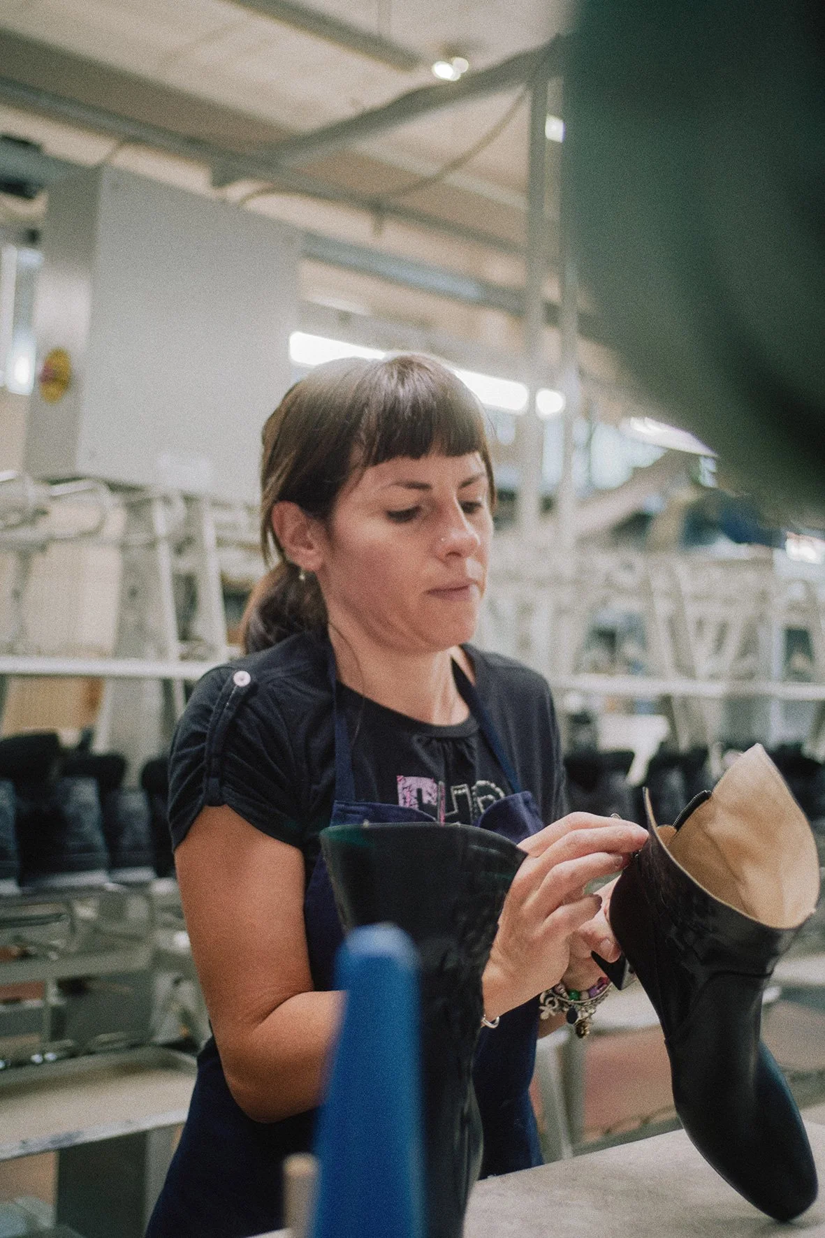 footwear quality control worker inspecting a boot in production workshop