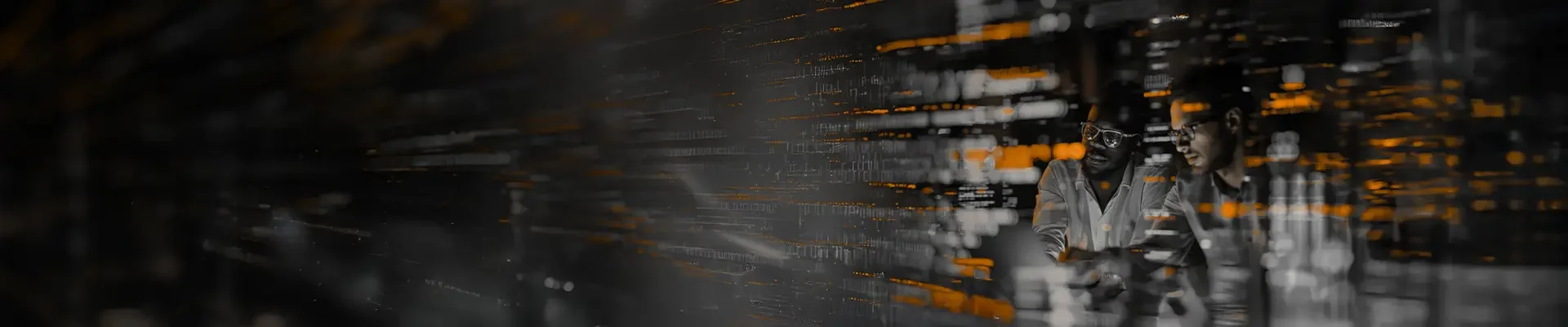 Two men working in a data center, looking at a tablet, surrounded by server racks with orange and white LED lights.