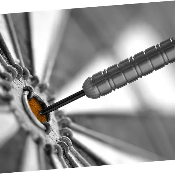 A close-up of a dart hitting the bullseye on a dartboard.