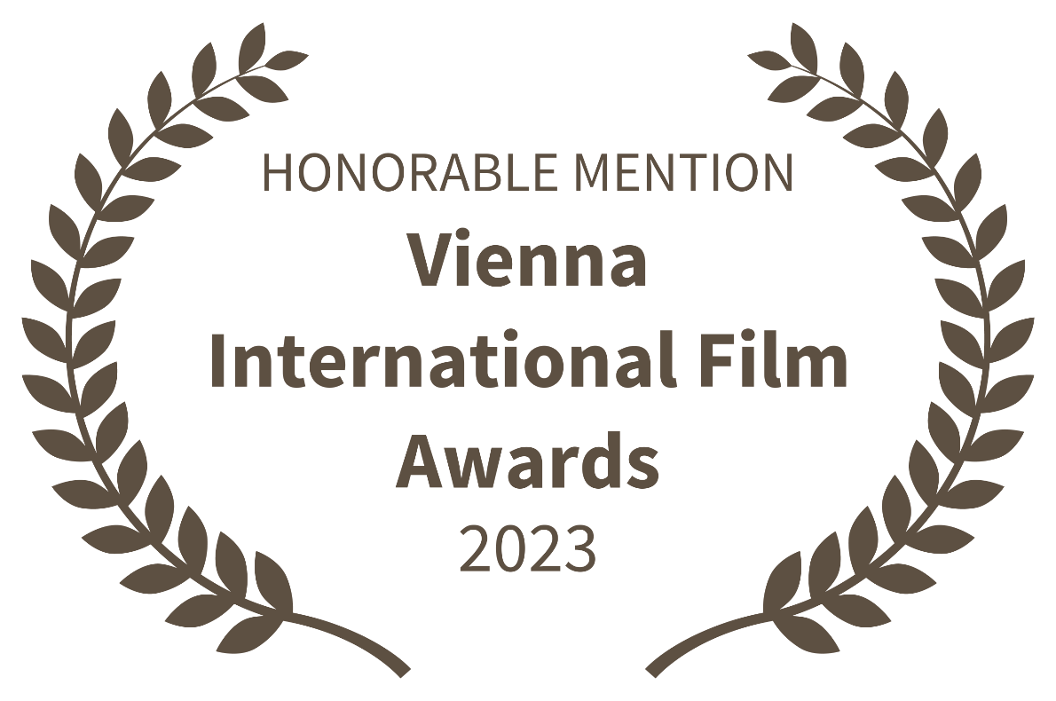 A laurel wreath surrounding the text 'Honorable Mention Vienna International Film Awards 2023'