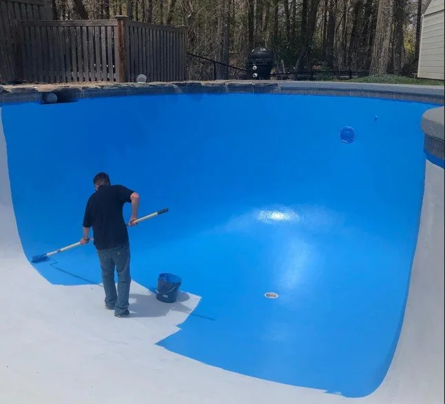 Applying durable blue epoxy resurfacing to renew the interior surface of a gunite pool.
