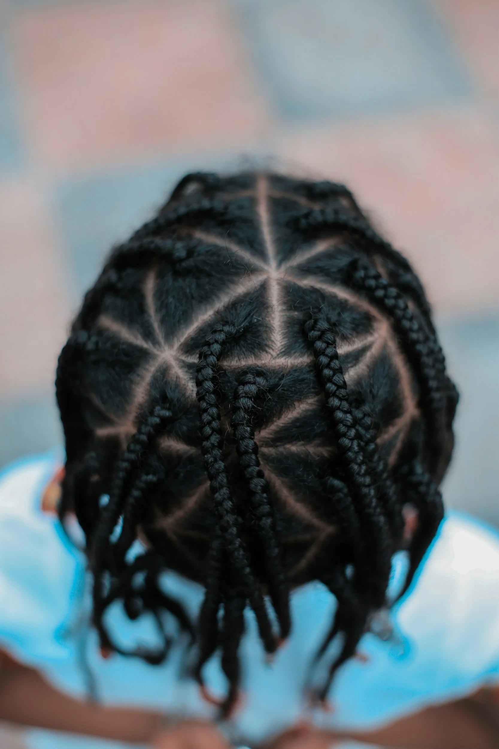 Top view of a child's head with intricate cornrow braided hairstyle.