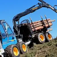 A Rottne F15 Forwarder operated along the crest of a hill with blue sky in the background, half full of logs and a mechanical arm extended out bringing more logs to the machine for transportation.