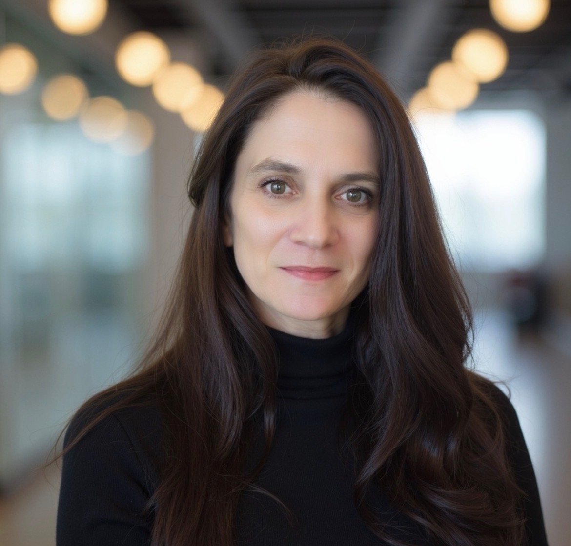 Woman with brown hair smiling wearing a black turtle neck