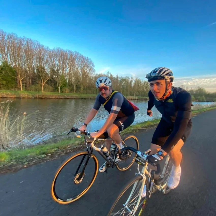 Cyclists by a river in the French countryside