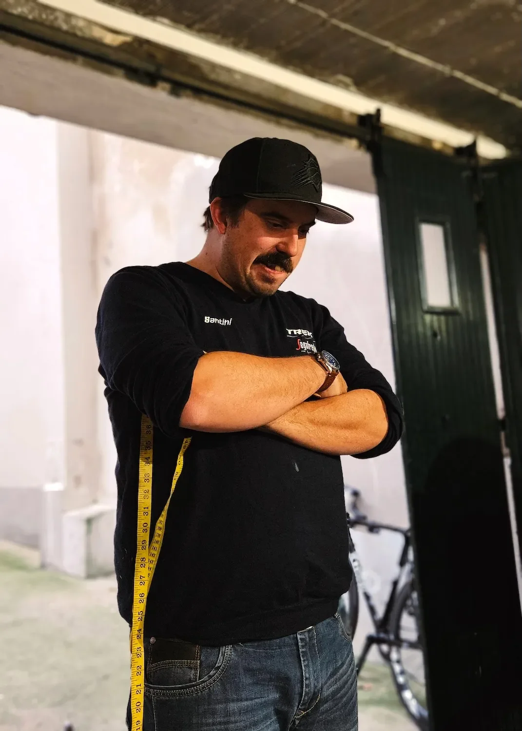 Bike fitter holding a yellow measuring tape.