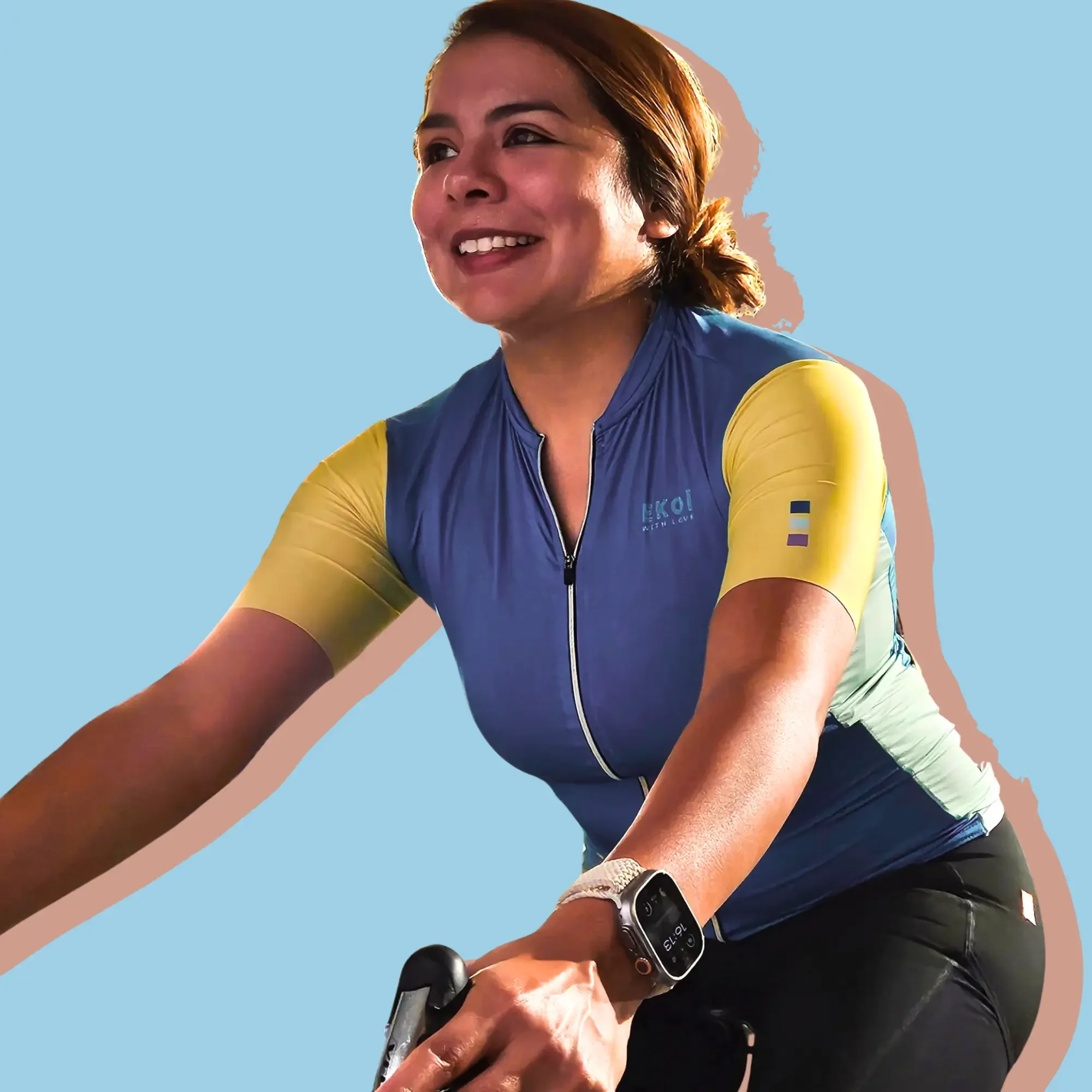 Woman on bike against pastel blue backdrop.