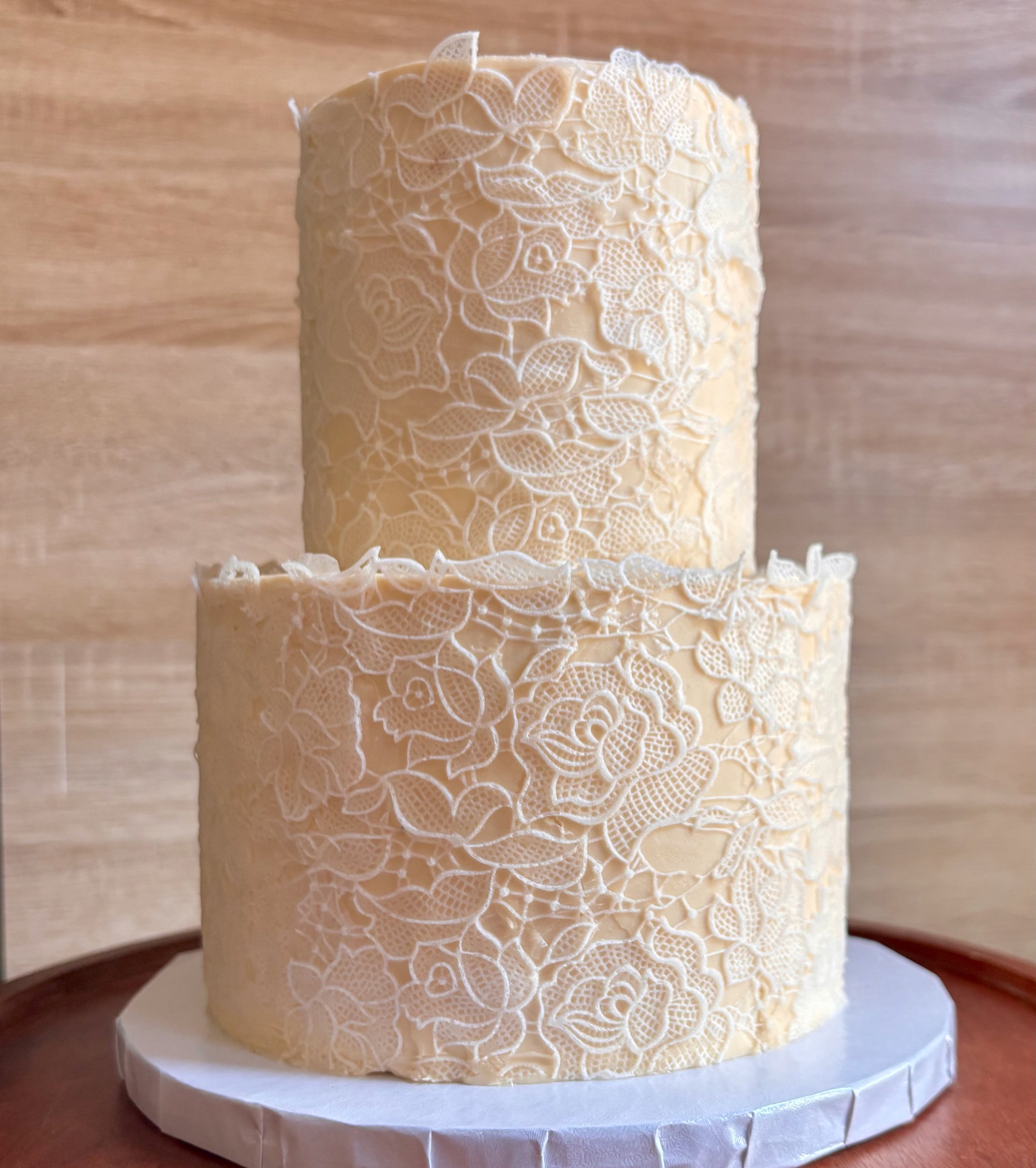 two tier ivory cake with floral cake lace around both tiers