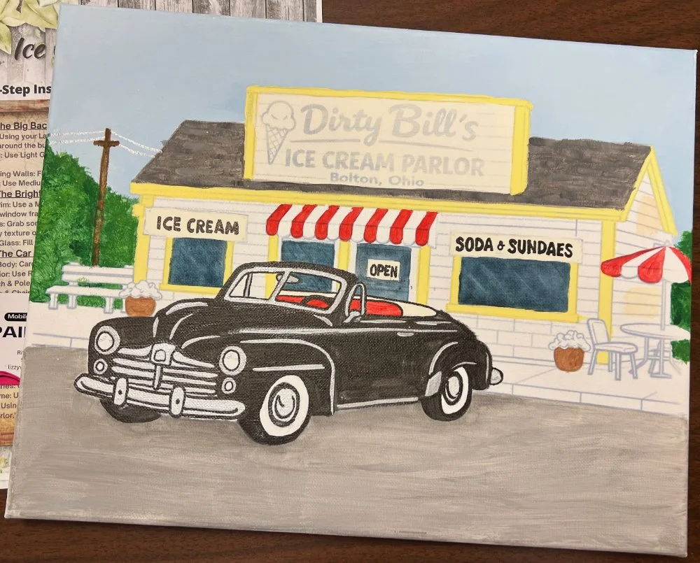 Painted depiction of an ice cream parlor named Dirty Bill's Ice Cream Parlor in Bolton, Ohio, with a vintage black convertible car parked out front, outdoor seating with a red and white umbrella, and decorative plants.