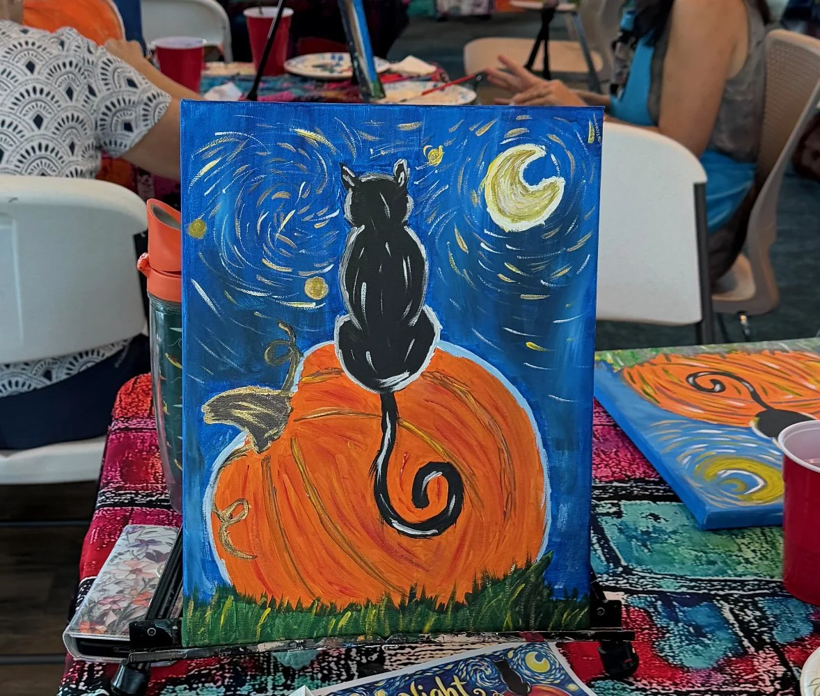 Painting of a black cat sitting on a large orange pumpkin under a night sky with swirling stars, moon, and grass at the bottom.