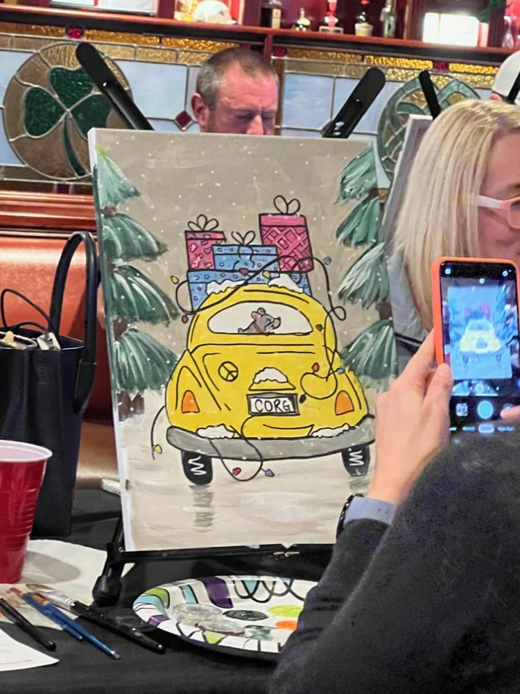 A painting of a yellow car with snow on it and a mouse inside, surrounded by Christmas presents and pine trees, with the license plate reading 'CORG'.